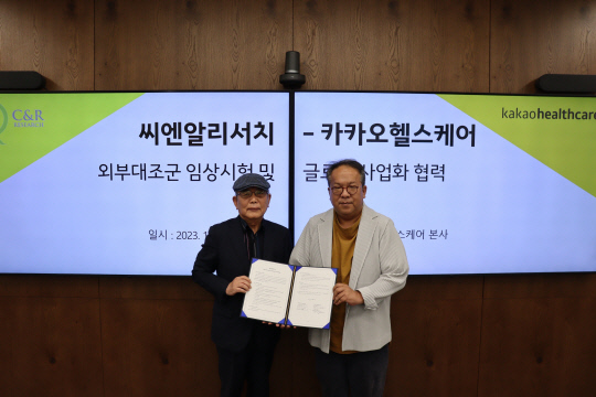 황희(오른쪽) 카카오헬스케어 대표와 윤문태 씨엔알리서치 대표가 카카오헬스케어 본사에서 '글로벌 임상시험 사업 공동 추진을 위한 MOU(업무협약)'를 맺고 기념사진을 촬영하고 있다. 카카오헬스케어 제공